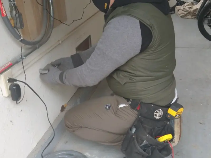 Electrician performing outlet wiring in a Greene garage